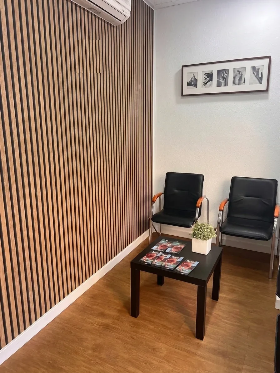 Sala de espera de FRATERSALUD con pared de madera